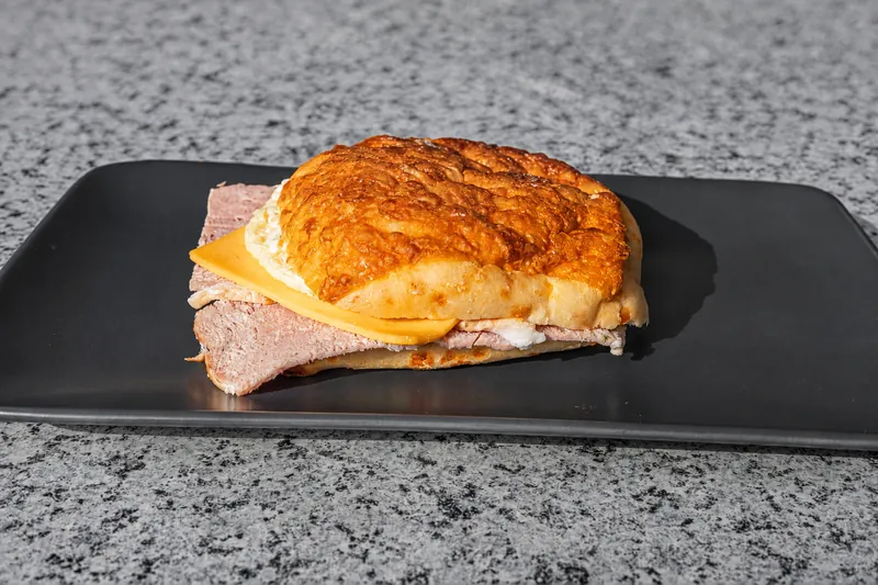 A croissant sandwich on a black plate