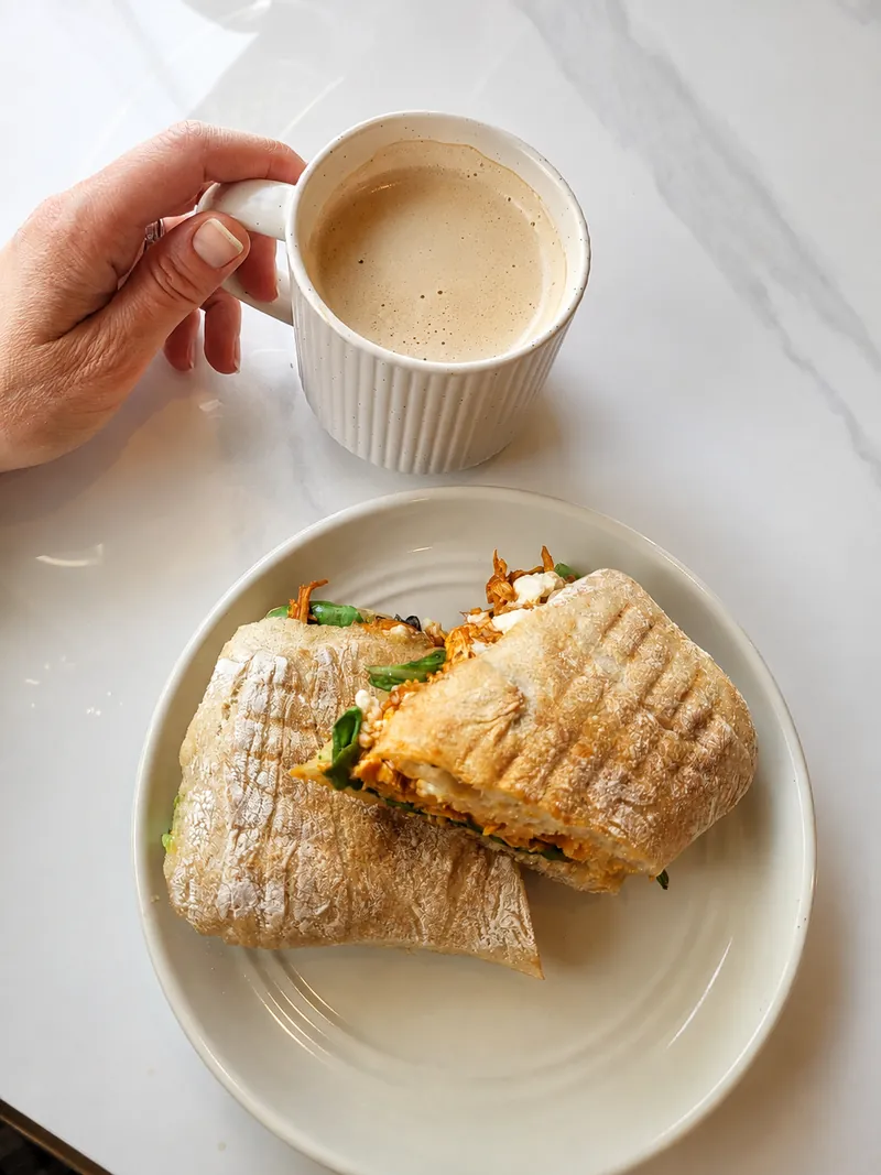 A toasted sandwich with a cup of coffee