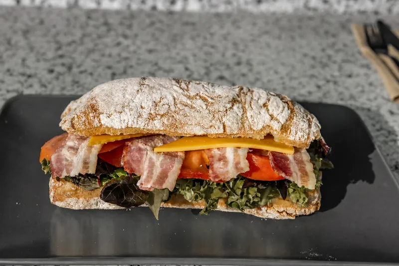 A filled sandwich on a black plate